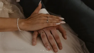 Fotografia ślubna – zbliżenie na dłonie pary młodej z obrączkami w czułym uścisku